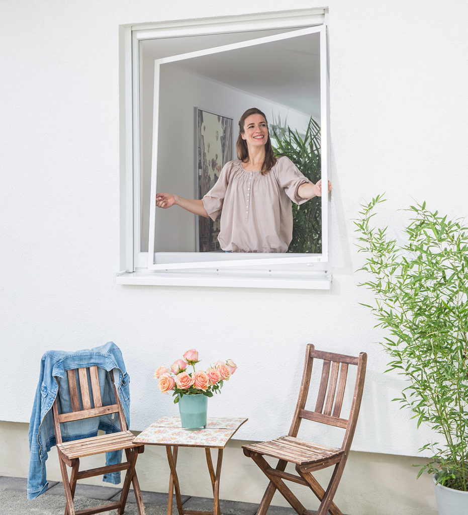 Frau am Fenster mit Insektenschutz in Stuttgart